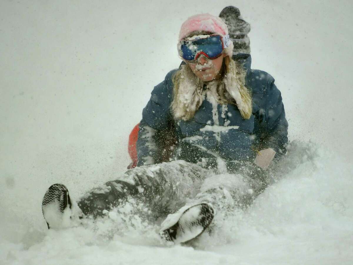 Friends Lucy Hurlbut, left, and Carly Guarino, both of Fairfield, sled in near white out conditions at Sturges Park in Fairfield, Conn. on Monday, February 1, 2021.