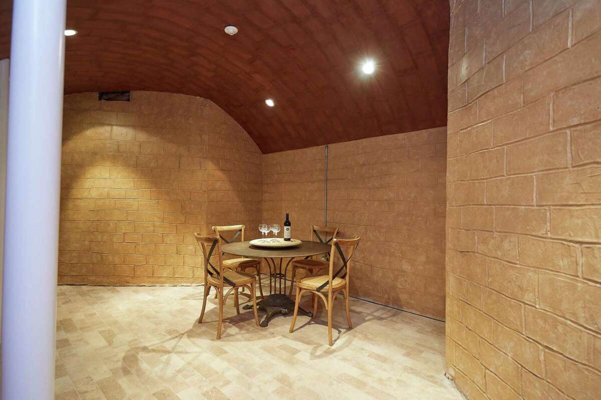 Wine cellar and tasting room at 17 Woodway Lane, Westport. From the Belgium block-lined driveway there is a forecourt that leads to the front entrance where French doors open into the two-story foyer, which features a graceful element of its own: a butterfly staircase with decorative railings. Inside, spacious rooms invite comfortable living, as well as entertaining, whether for an intimate gathering or on a grand scale. To facilitate festivities, there is a wine cellar and tasting room as well as a wet bar in the basement, which also features a barrel-vaulted ceiling.