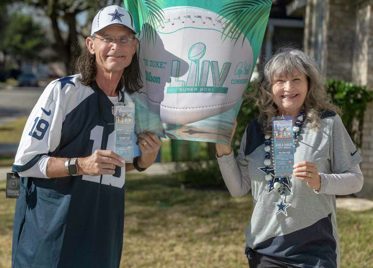 Steve and Charlie Pelham pose Wednesday outside their North Side home with some of the items from their 2020 Super Bowl party. The husband and wife had hosted the event for 14 years but canceled it this year due to the coronavirus pandemic.