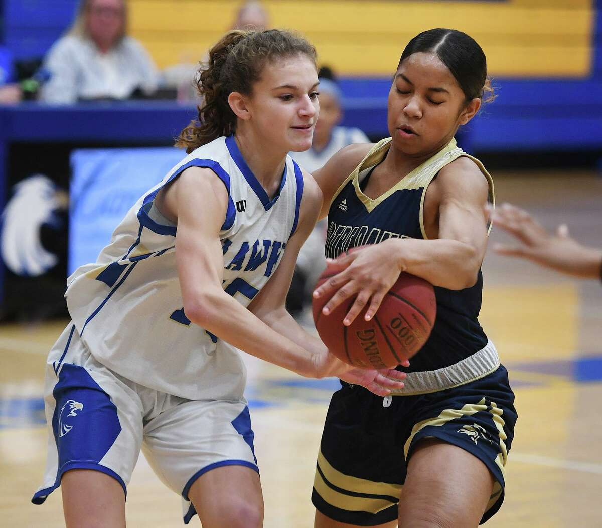 Newtown's Emma Magazu, left, is tied up by Notre Dame of Fairfield defender Aizhanique Mayo during the first half of their SWC girls basketball game at Newtown High School in Newtown, Conn. on Thursday, January 23, 2020.