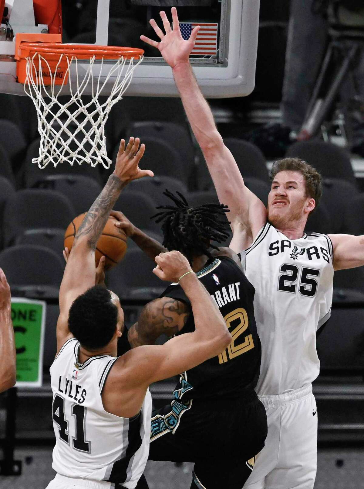 Memphis Grizzlies' Ja Morant, center, attempts to shoot against San Antonio Spurs' Jakob Poeltl (25) and Trey Lyles during the second half of an NBA basketball game, Saturday, Jan. 30, 2021, in San Antonio. (AP Photo/Darren Abate)