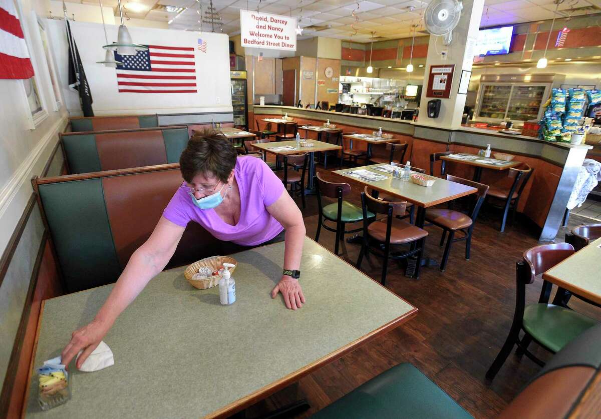 Dorothy Agostino sets up a table inside the dining room of the Bedford Street Diner in Stamford, Connecticut on June 16, 2020.