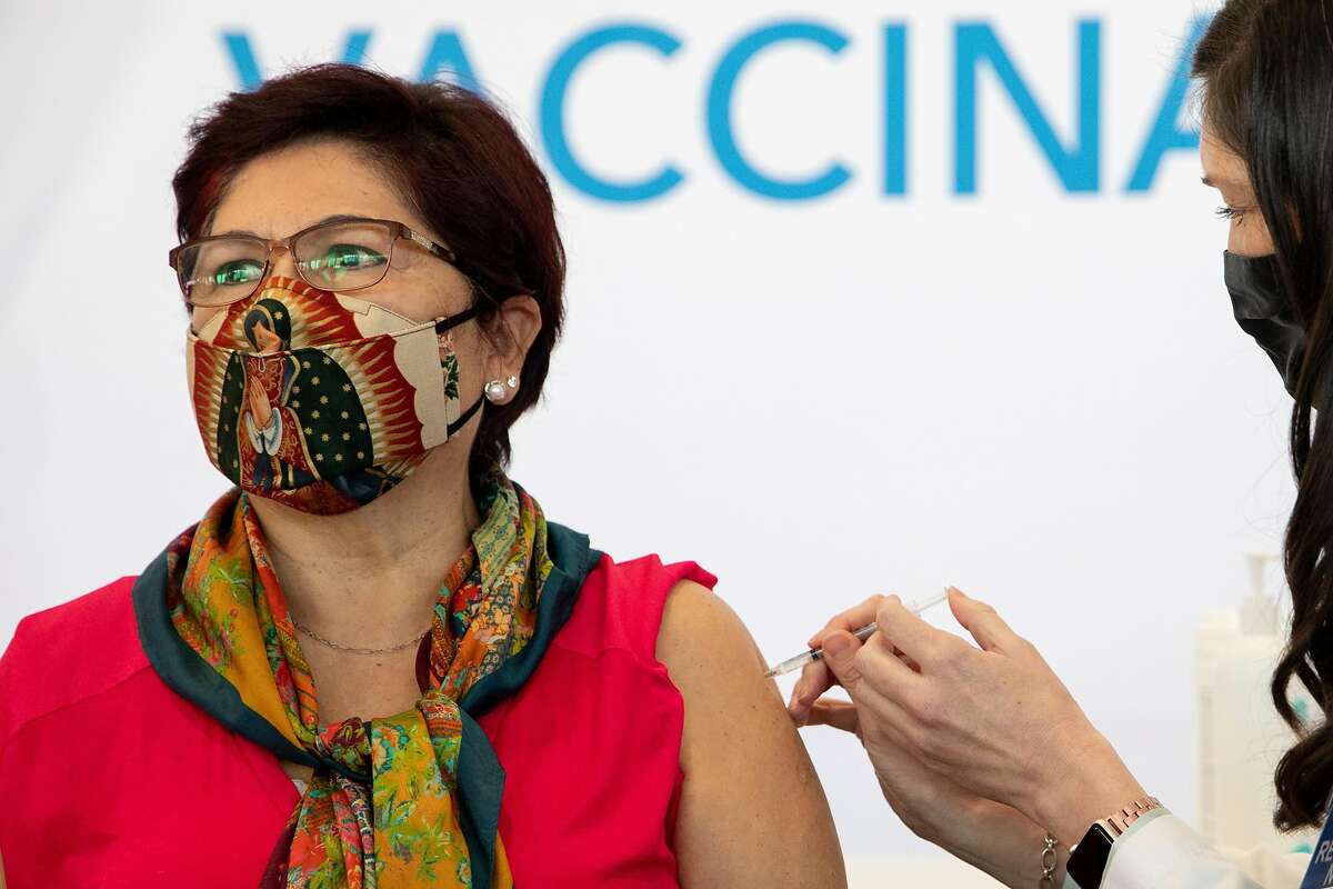 Irene Villa, 72, receives her first dose of the Pfizer COVID-19 vaccine ahead of the grand opening of a mass COVID-19 vaccination site at Moscone South in San Francisco.