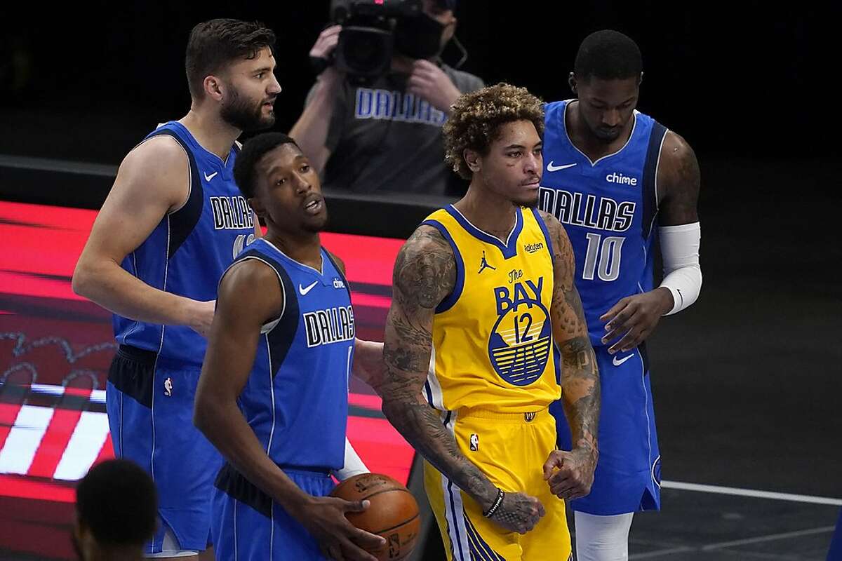 Golden State Warriors' Kelly Oubre Jr. (12) flexes after being fouled by Dallas Mavericks' Dorian Finney-Smith (10) on a shot attempt during the first half of an NBA basketball game in Dallas, Thursday, Feb. 4, 2021. The Mavericks' Josh Richardson, front, and Maxi Kleber, rear, stand nearby. (AP Photo/Tony Gutierrez)