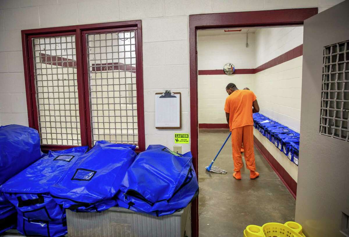 A detainee mops the floor at the intake station at the Stewart Detention Center in Lumpkin, Ga.