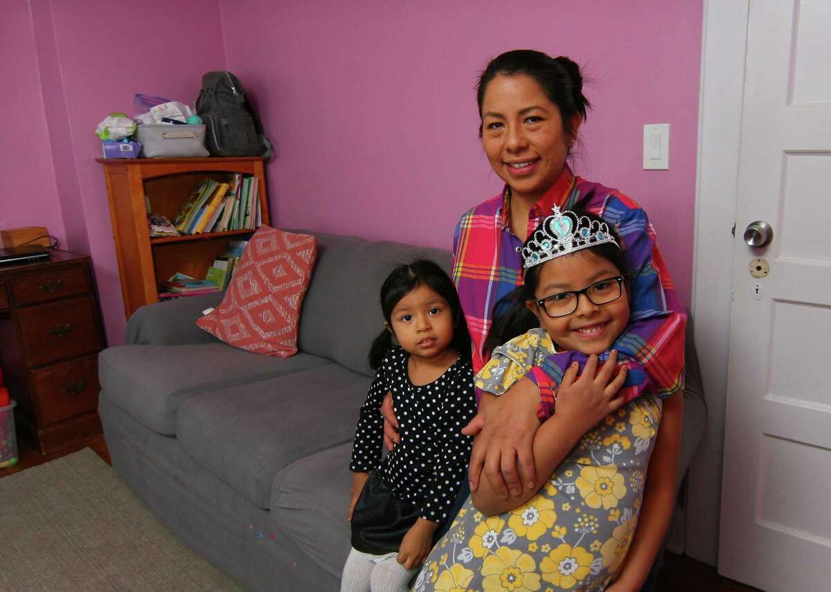 Flor Melgar poses with her children Annie Arrecis, 2, and Sofia Arrecis, 5, at their home in Port Chester, New York, on Saturday Jan. 30, 2021. Melgar receives help in educating her children through the Giving Fund and Family Centers.
