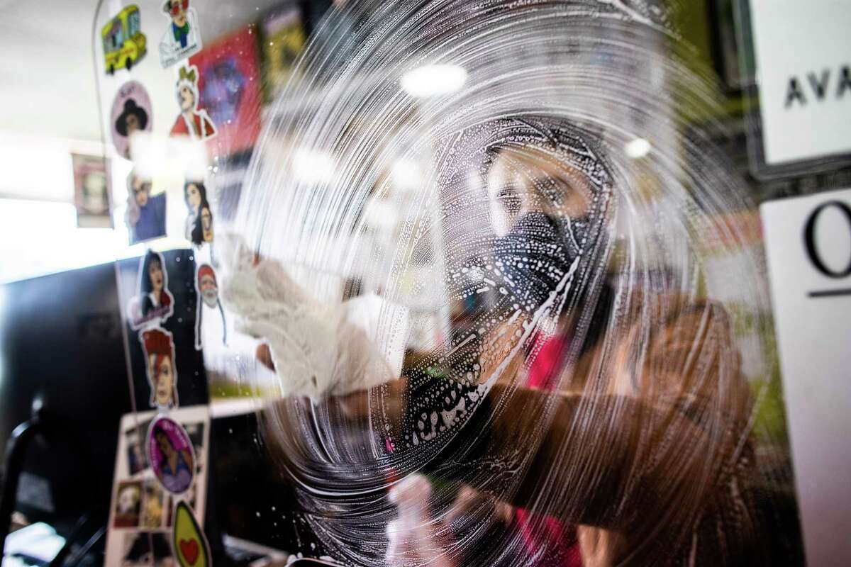 Steven Suarez, 33, disinfects his work space at Cactus Music, Wednesday, Feb. 3, 2021, in Houston. Suarez lost his job at Academy after a disagreement with a client at the sporting goods store who didn’t want to wear a protective mask.