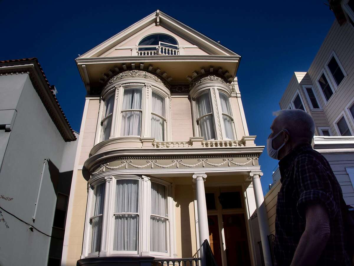 Denny Smith admires the curved glass in the windows of a victorian home on Friday, Feb. 5, 2021 in San Francisco, Calif.