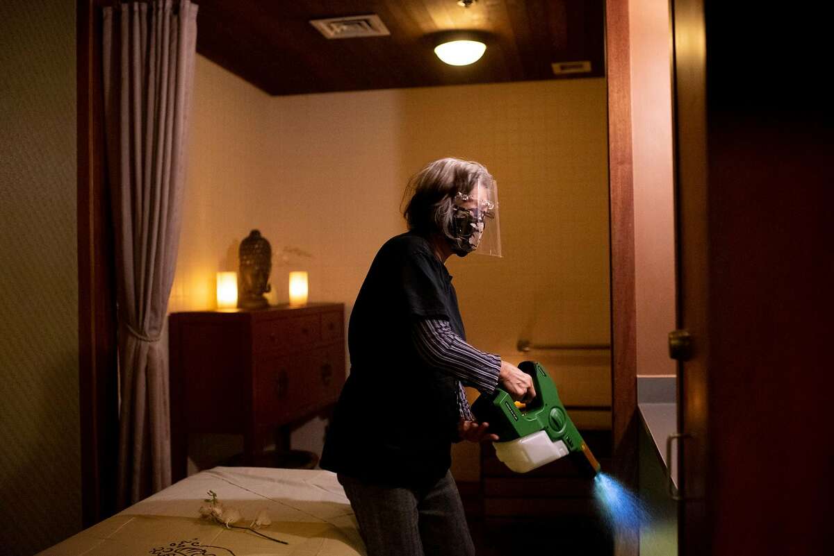 Jenny Chow, a spa attendant, uses an electrostatic sprayer to disinfect a massage room at Kabuki Springs and Spa in Japantown in San Francisco.