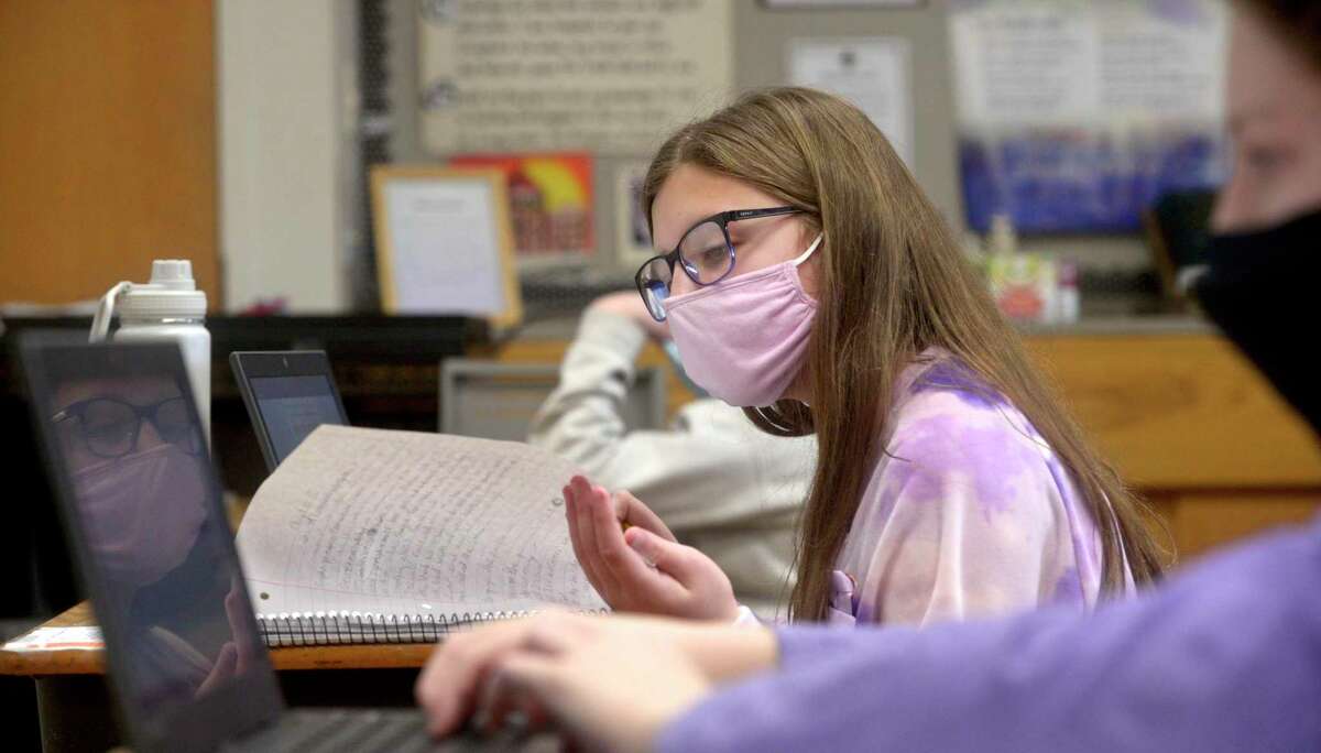 Gianna Alfano, of Danbury, age 11, of Danbury, looks at her notes during a sixth grade science class at St Joseph School. Catholic schools like St Joseph have been able to stay open five days a week for all students during the coronavirus pandemic. Friday, February 5, 2021, in Danbury, Conn.