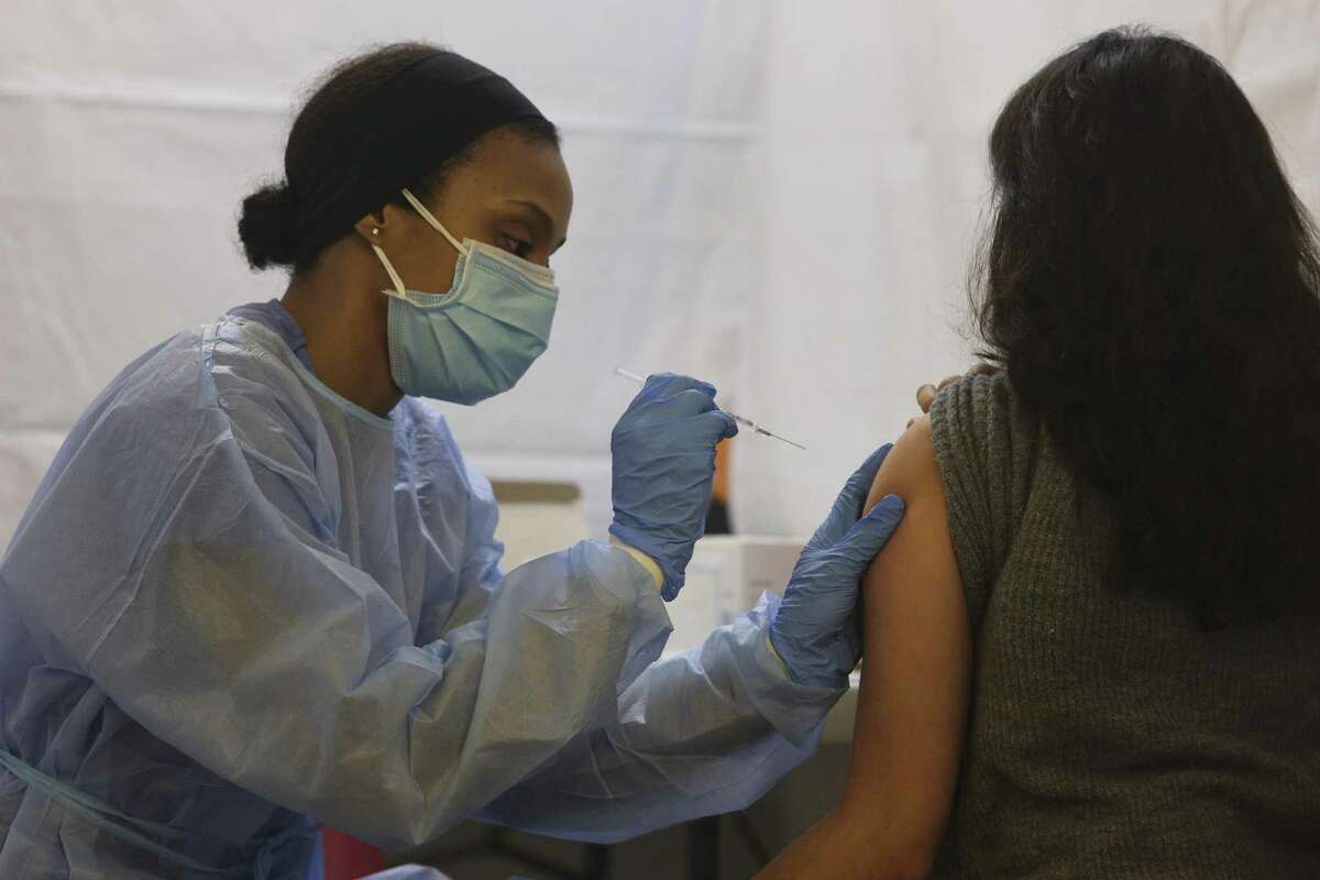 A healthcare worker administers the Pfizer BioNTech Covid-19 vaccine at a vaccination site inside a church in the Bronx borough of New York, U.S., on Friday, Feb. 5, 2021. Restaurant workers, taxi drivers and workers at developmentally-disabled facilities could become eligible to receive Covid-19 vaccines if local governments choose to include them, Governor Cuomo said. Photographer: Angus Mordant/Bloomberg