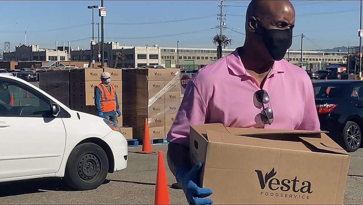 Barry Bonds places boxes of food into vehicles during a Marin-San Francisco Food Bank distribution in Lot A near Oracle Park on Jan. 5, 2021.
