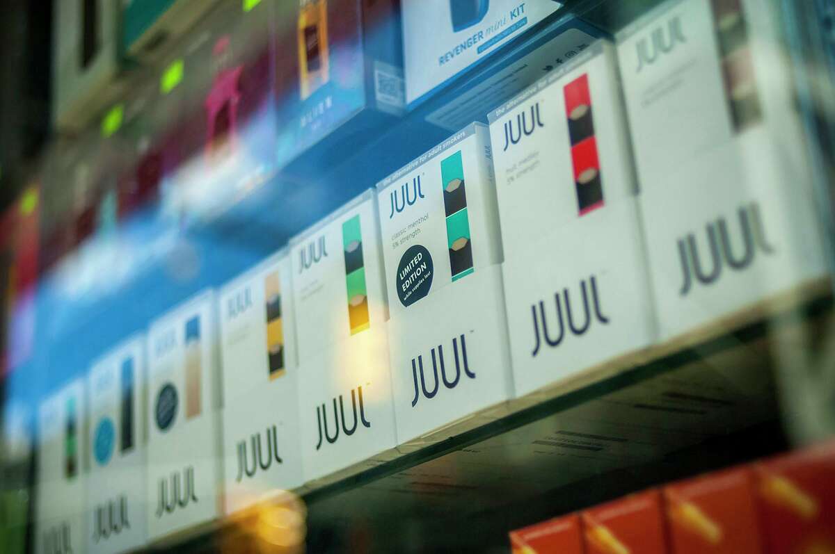 A selection of Juul brand vaping supplies on display in the window of a vaping store in New York.
