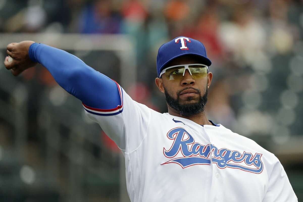 FILE - In this March 11, 2020, file photo, Texas Rangers' Elvis Andrus tosses a ball before a spring training baseball game against the San Francisco Giants in Surprise, Ariz. The Rangers traded Andrus to the Oakland Athletics on Saturday, Feb. 6, 2021. Texas is sending the 32-year-old Andrus, catcher Aramis Garcia and $13.5 million to the A's for designated hitter Khris Davis, along with catcher Jonah Heim and right-hander Dane Acker. (AP Photo/Elaine Thompson, File)