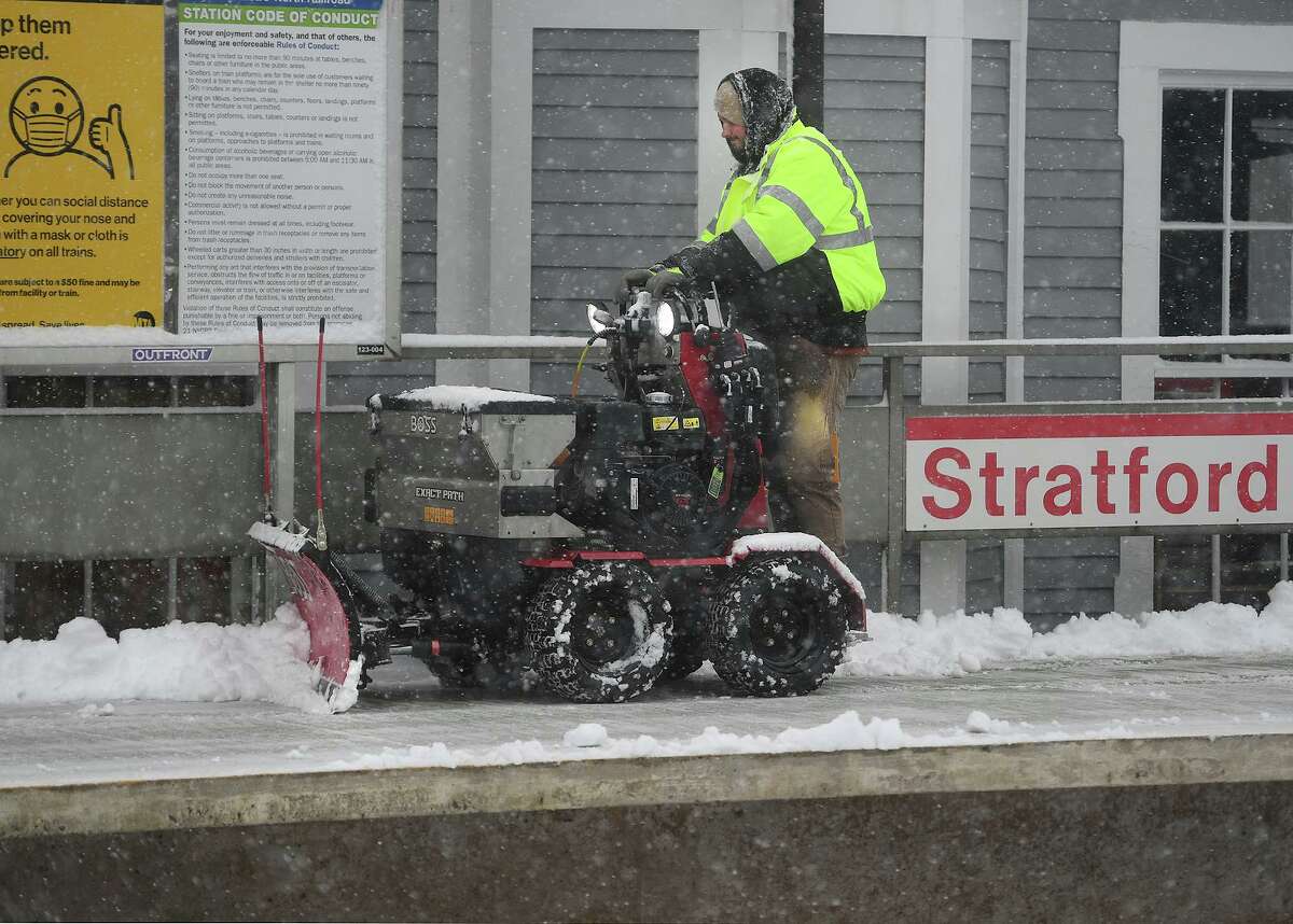 Workers clear snow during the height of the storm at the Stratford Train Station in Stratford, Conn. on Sunday, February 7, 2021.