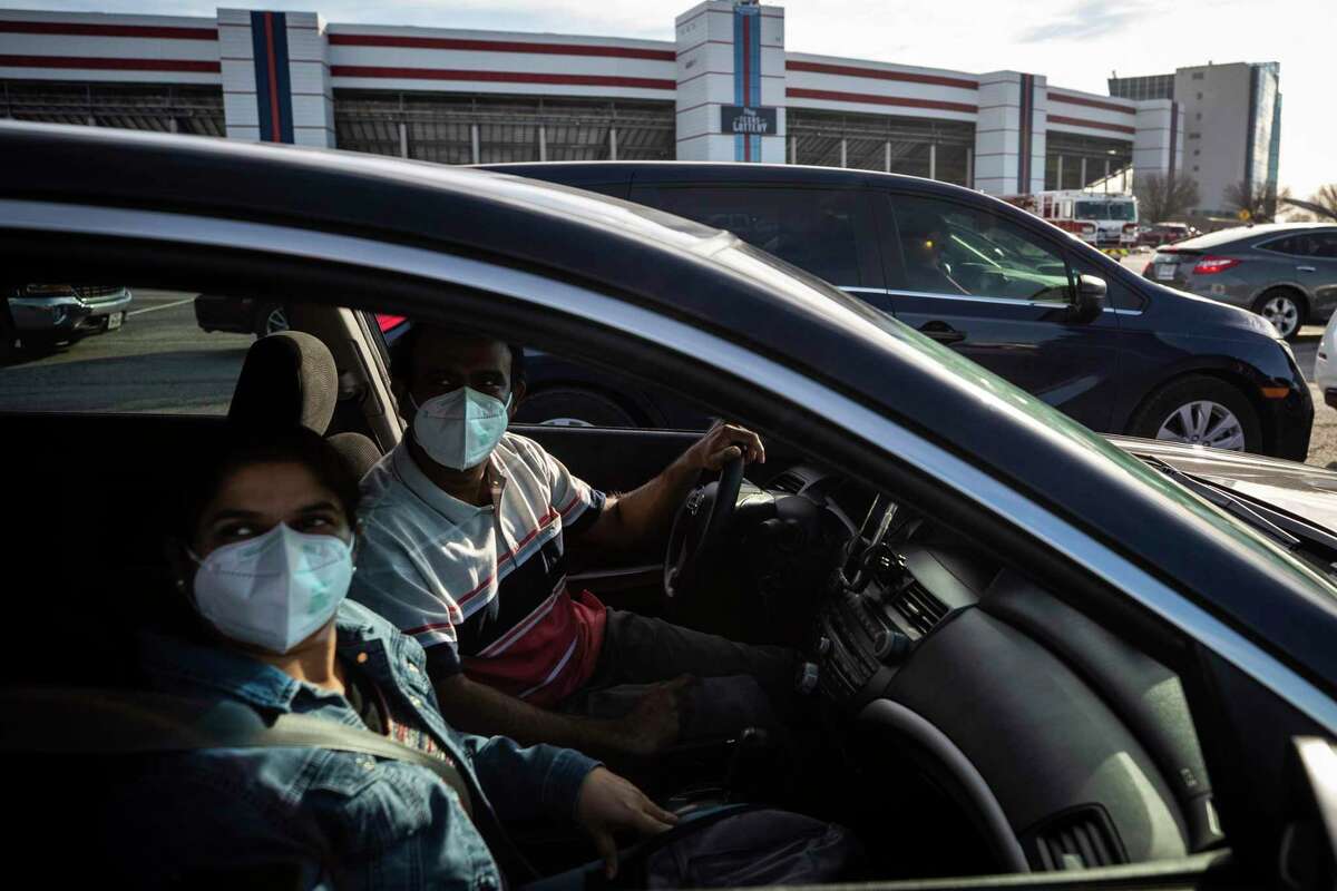 Swami Vembu, right, and Ash Sairan sit in a vehicle for 15 minutes after they received a COVID-19 vaccine, Tuesday, Feb. 2, 2021, at the Texas Motor Speedway in Fort Worth, Texas. (Yffy Yossifor/Star-Telegram via AP)