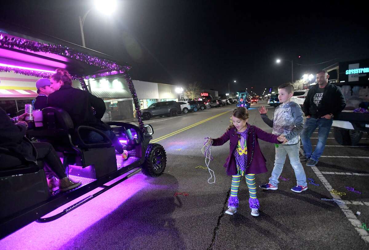 Participants in the Mid-County Cruisers' Mardi Gras parade toss beads and other swag as they make their way through Port Neches and Nederland Saturday night. Photo taken Saturday, February 6, 2021 Kim Brent/The Enterprise