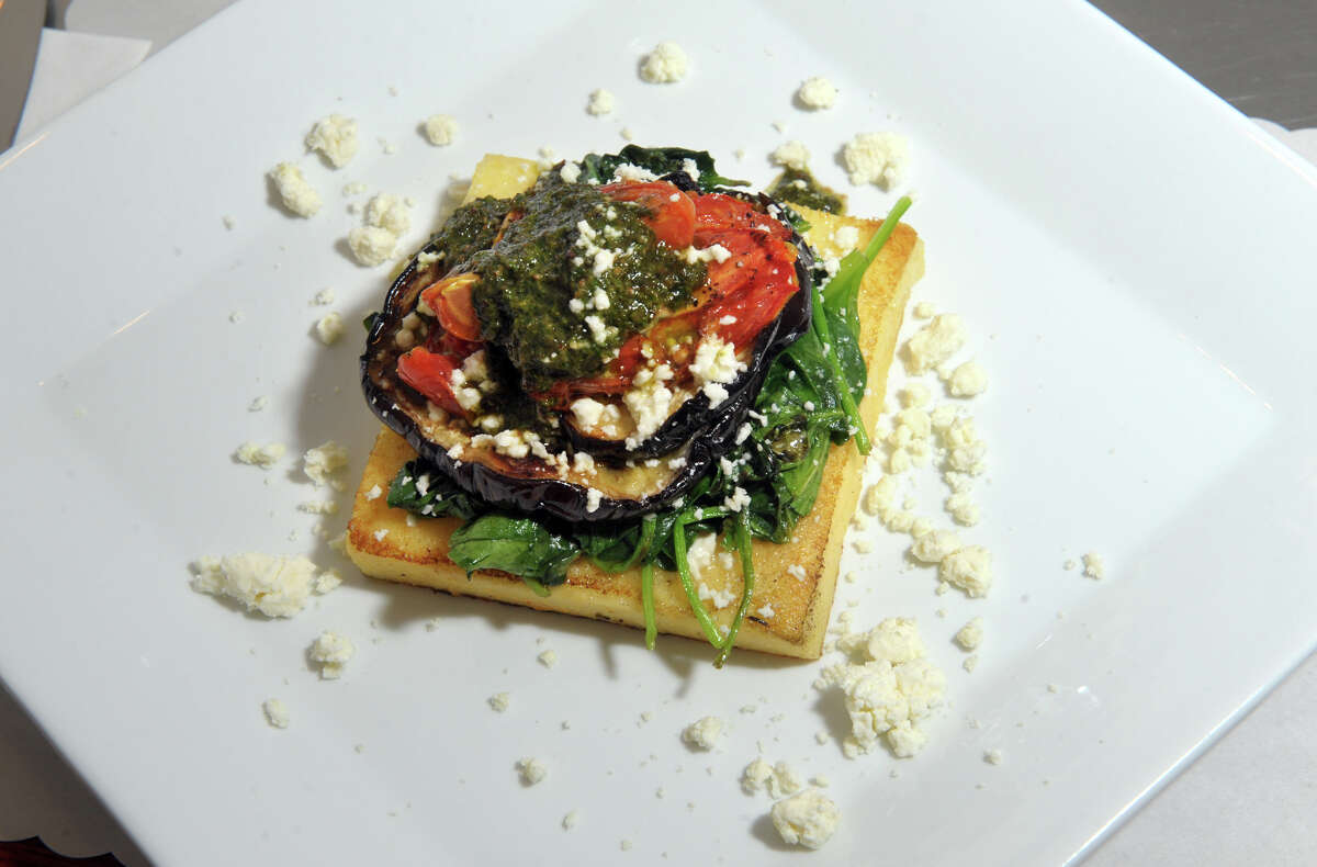 Eggplant Polenta Napoleon at Capuli Restaurant, in Westport, Conn. Feb. 8, 2021. Baked polenta cake layered with spinach, roasted eggplant, roasted Roma tomatoes, basil pesto and feta cheese.