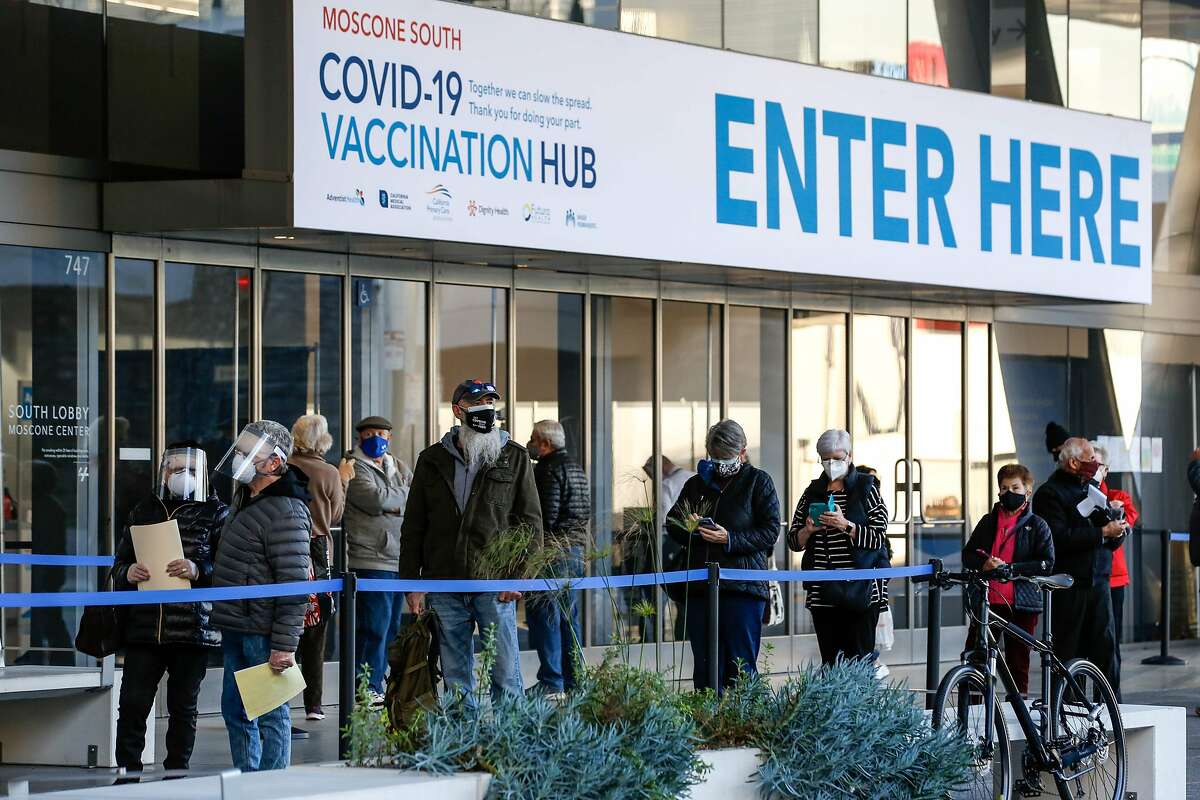 People stand in line at the mass vaccination site at San Francisco's Moscone Convention Center that opened today for healthcare workers and people over 65 on February 5, 2021 in San Francisco, California. (Photo by Amy Osborne / AFP) (Photo by AMY OSBORNE/AFP via Getty Images)