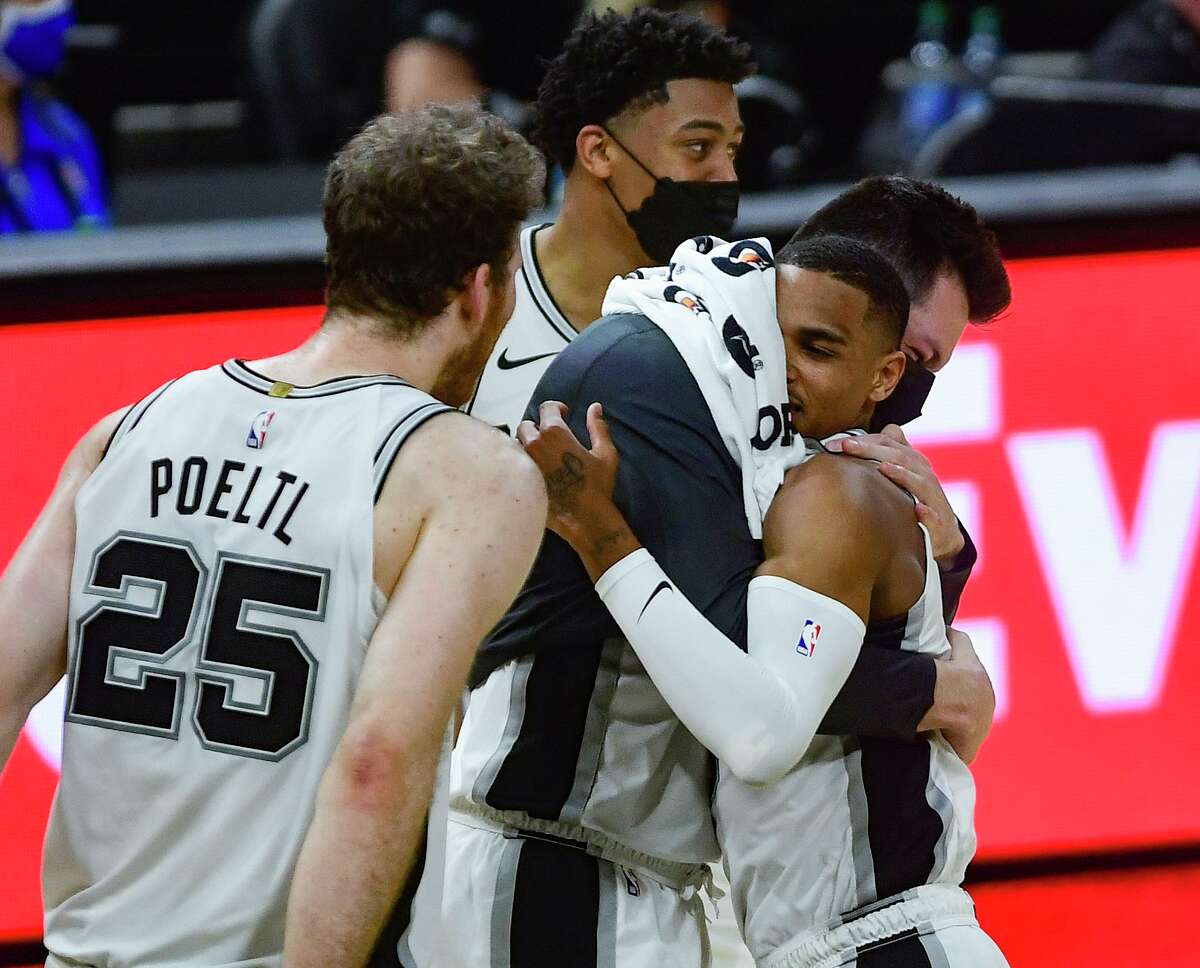 DeJounte Murray of the San Antonio Spurs is embraced by teammate Drew Eubanks after scoring on a three-point shot later in NBA action against the Golden State Warriors in the AT&T Center on Monday, Feb. 8, 2021.