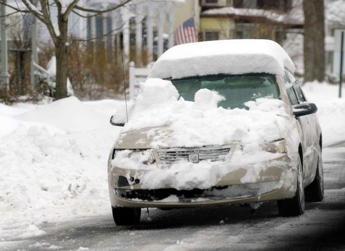 A car driving in New Milford, Connecticut, covered in snow in 2014.