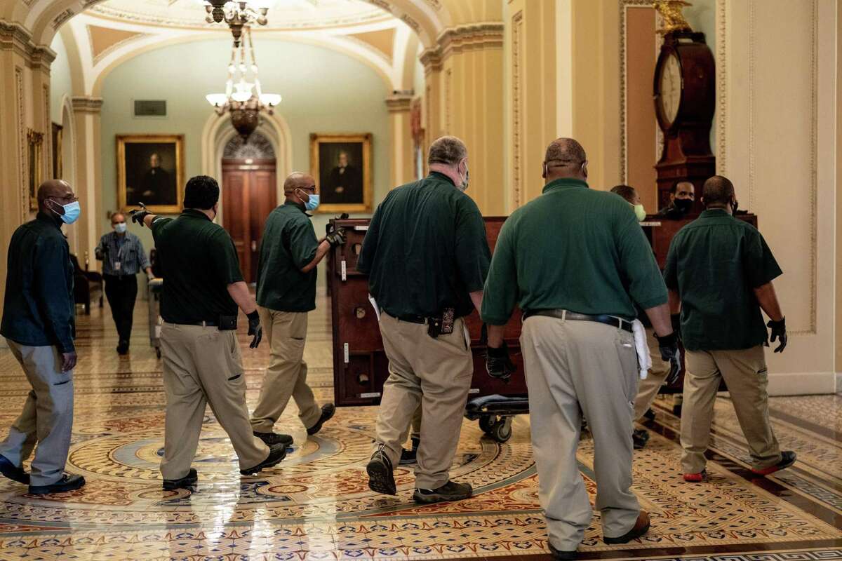 Capitol workers move furniture at the Capitol in Washington on Monday, Feb. 8, 2021, as the Capitol is prepared for the Senate impeachment trial of former President Donald Trump, scheduled to begin on Tuesday. (Erin Schaff/The New York Times)