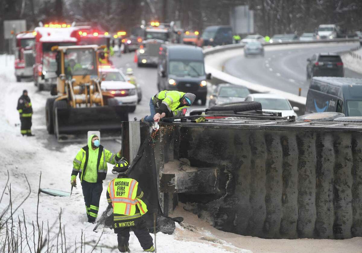Ansonia firefighters are on the scene of an overturned salt truck that temporarily closed Route 8 northbound above exit 19 in Ansonia, Conn. on Tuesday, February 9, 2021.