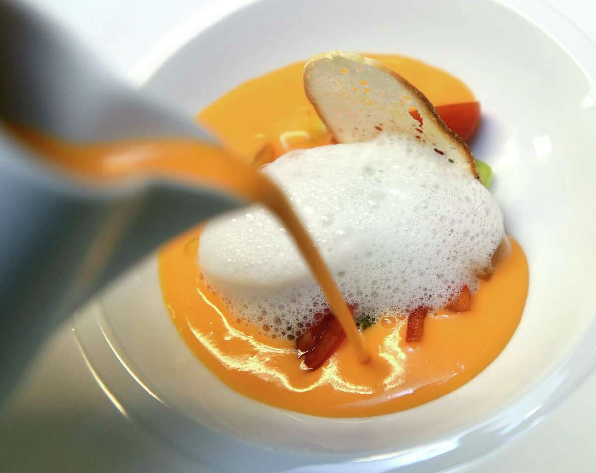 Olea executive chef and co-owner Manuel Romero prepares a a bowl of gazpacho at his restaurant on High St. in New Haven .
