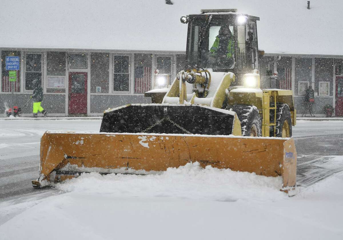 Workers clear snow during the height of the storm at the Stratford Train Station in Stratford, Conn. on Sunday, February 7, 2021.