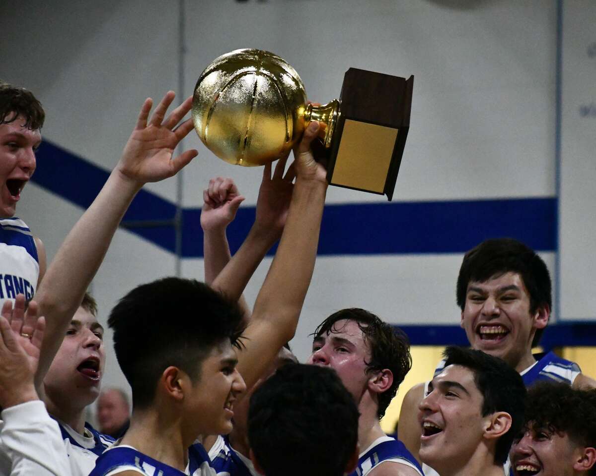 Senior Chris Urbina hoists the district title as he and his teammates celebrate.