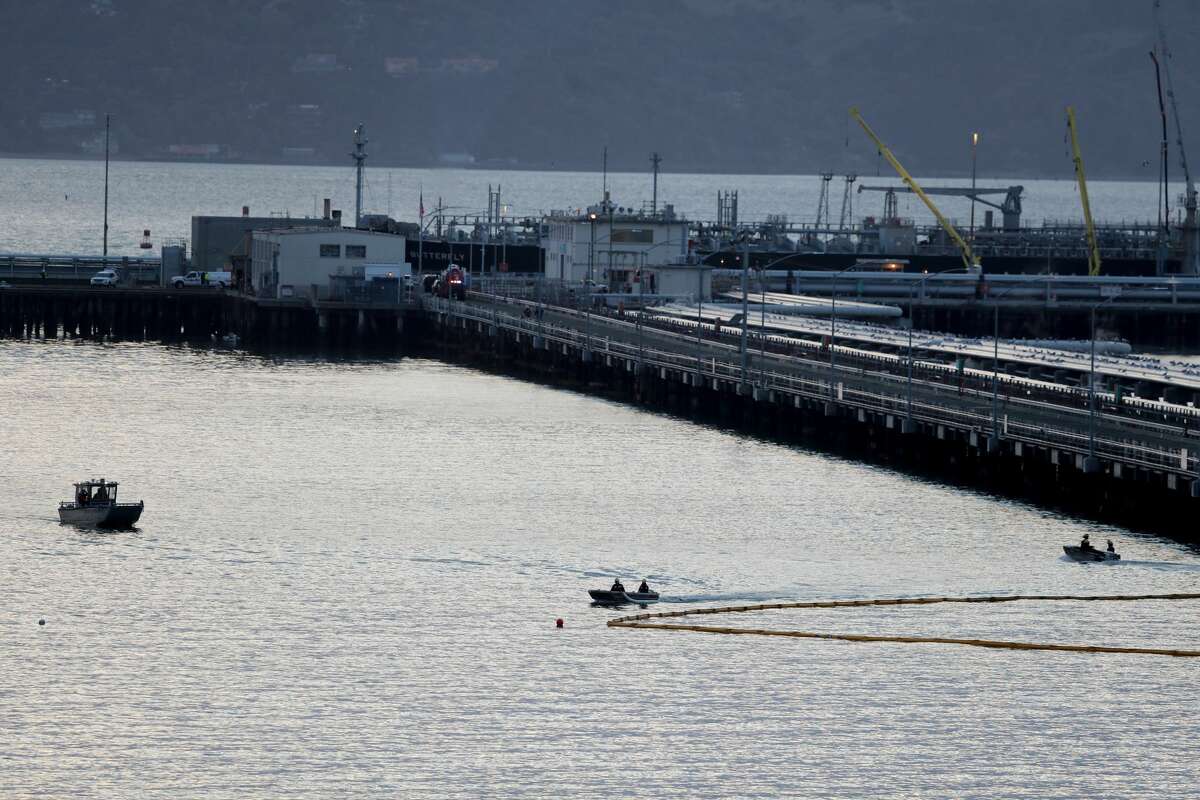 Chevron and fire-agency crews respond to a five-gallon-per-minute petroleum product leak in the waters of Point Richmond as an absorbent boom is placed next to the Chevron Richmond Long Wharf in Richmond, Calif., on Tuesday, Feb. 9, 2021.