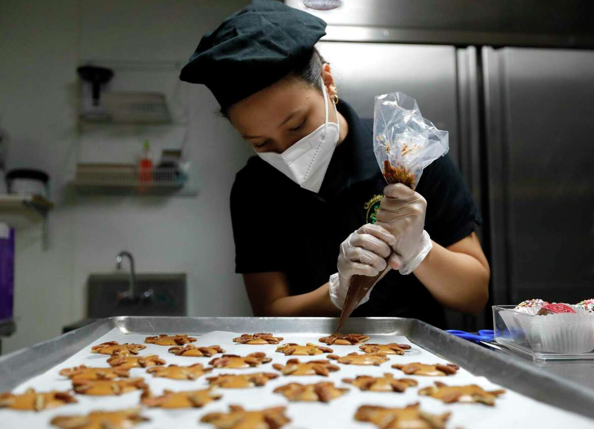 Isabella Macias pipes chocolate onto treats in preparations for Valentine’s Day customers at Chocolate Passion, Tuesday, Feb. 9, 2021, in Conroe.