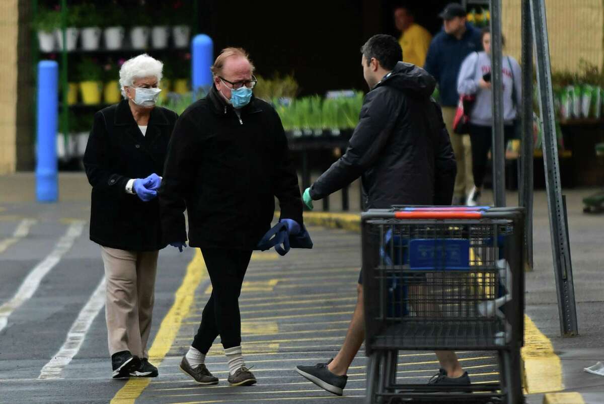 Shoppers come in and out of Walmart Saturday, March 28, 2020, in Norwalk, Conn.