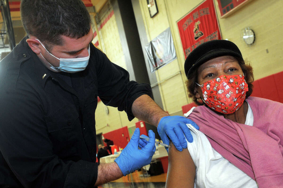 Ken Benedict of the Bridgeport Fire Department administers a COVID-19 vaccine to Lucy Gagliano, of Bridgeport, at the weekly vaccination clinic held in the gymnasium of Central High School in Bridgeport, Conn. Feb. 10, 2021.