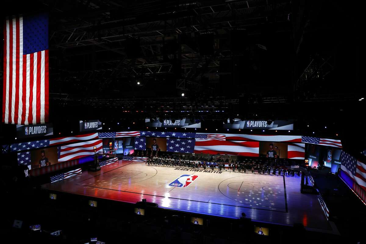 LAKE BUENA VISTA, FLORIDA - AUGUST 30: Players take a knee during the national anthem before the start of a game between the Dallas Mavericks and the LA Clippers in Game Six of the Western Conference First Round during the 2020 NBA Playoffs at AdventHealth Arena at ESPN Wide World Of Sports Complex on August 30, 2020 in Lake Buena Vista, Florida. (Photo by Kevin C. Cox/Getty Images)