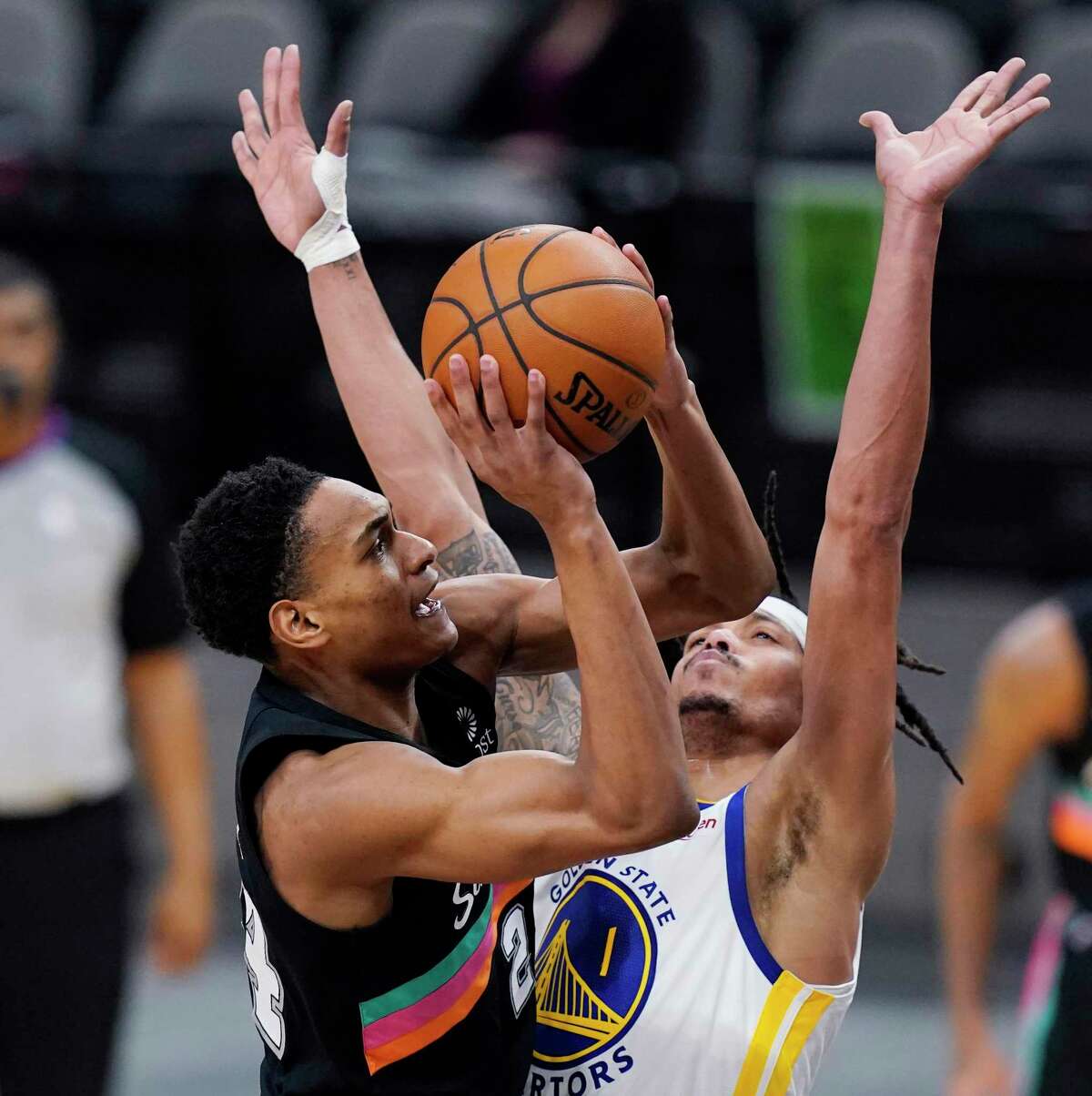 San Antonio Spurs guard Devin Vassell (24) shoots over Golden State Warriors guard Damion Lee (1) during the first half of an NBA basketball game in San Antonio, Tuesday, Feb. 9, 2021. (AP Photo/Eric Gay)