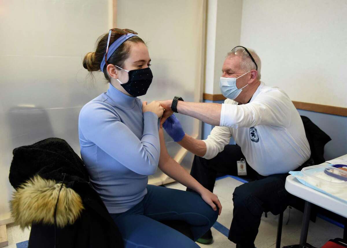 New Haven resident Caroline Beit, an EMT, receives the second dose of her COVID-19 vaccine from Jim Anderson, a member of the GEMS vaccination team, at the Town of Greenwich clinic at Town Hall in Greenwich on Jan. 28, 2021. The town will be providing Moderna boosters to eligible people at clinics on Nov. 10 and Nov. 17.