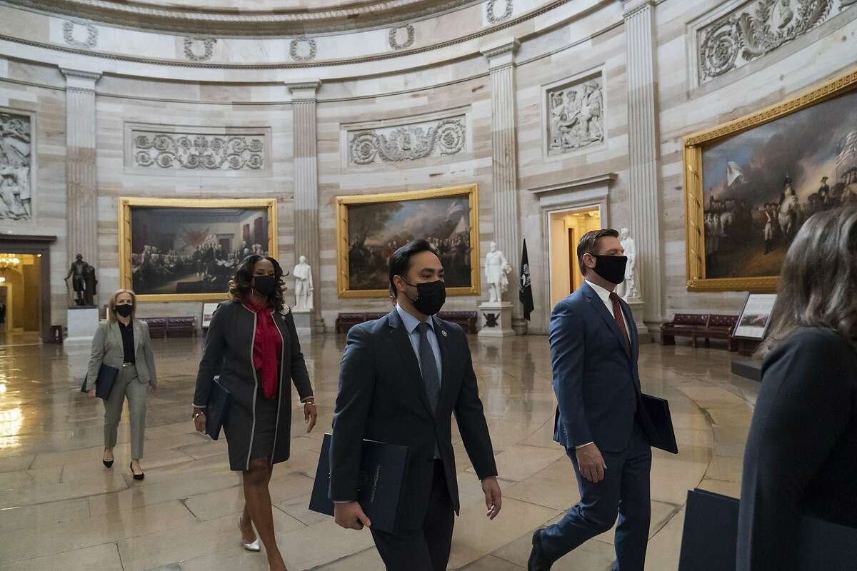 Rep. Eric Swalwell of Dublin (front right), Rep. Joaquin Castro of Texas, Rep. Ted Lieu of Torrance (Los Angeles County), Delegate Stacey Plaskett of the Virgin Islands and Rep. Madeleine Dean of Pennsylvania walk through the Rotunda with the Democrats’ other impeachment managers for the trial of former President Donald Trump.