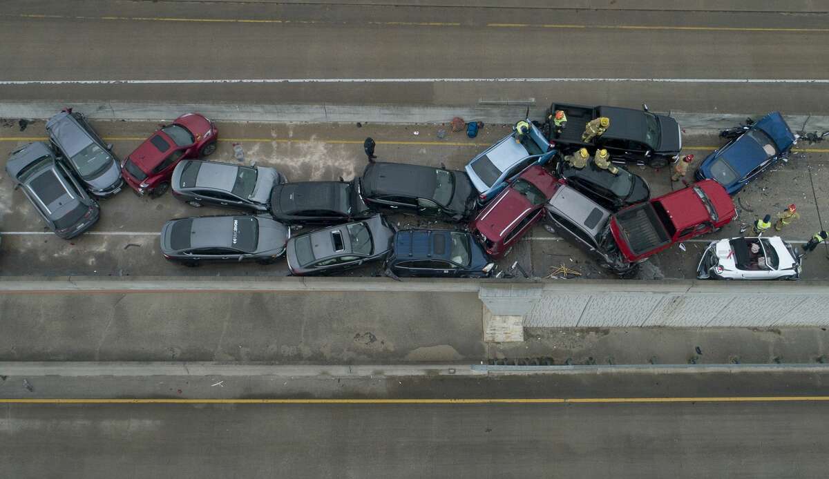 Emergency responders work at a multi-car pileup on Sate Highway 45 near Briarwick Drive on Thursday, Feb. 11, 2021, in Austin, Texas. (Jay Janner/Austin American-Statesman via AP)