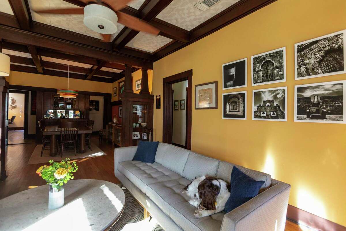 The living room in the 100-year-old Sears Craftsman bungalow of Tina Reck-Guerra and Michael Guerra has its original wood trim, coffered ceilings and built-ins. Their dog Blaze approves.