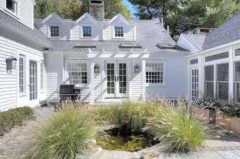 Pre-renovation, the pea-gravel courtyard included the existing pond ringed by a boxwood hedge. Wanting to make the space a special area to relax, the Shahids added blue stone pavers and a patio, and ornamental grass to bring in color and softness. "Our ducks like to jump in for a swim every now and then," Charlotte says.