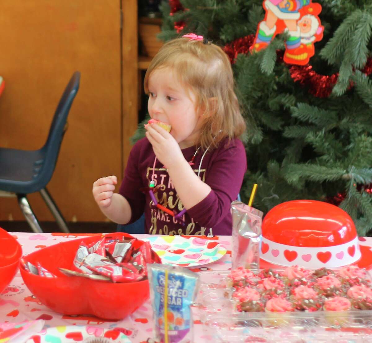 A Trinity Lutheran preschool student enjoys a cupcake during a Valentine's Day party in Lynne Gatz's classroom on Thursday. (Kyle Kotecki/News Advocate)