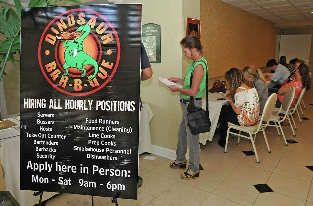 Applicants fill out applications in the lobby of the Best Western Franklin Square Inn for jobs at Dinosaur Bar-B-Que. (Lori Van Buren / Times Union)