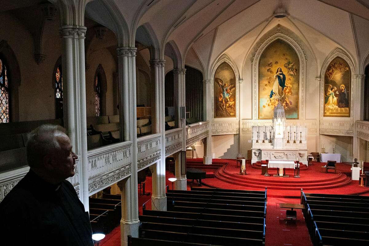 Father John Ardis look out over the main sanctuary space of Old Saint Mary's Cathedral in San Francisco, Calif. Monday, February 8, 2021. The cathedral is at risk of shutting down due to loss of revenue from visitors due to the COVID-19 pandemic. They owe $250,000 in insurance to the Archdiocese and revenue has plummeted, leading to layoffs to administrative staff and priests, with old infrastructure still in desperate need of repair.