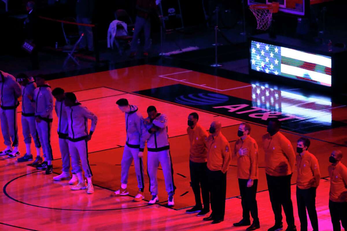 The Houston Rockets stand on the court for the National Anthem before the start of the first half of an NBA basketball game at Toyota Center, in Houston, Thursday, February 11, 2021.