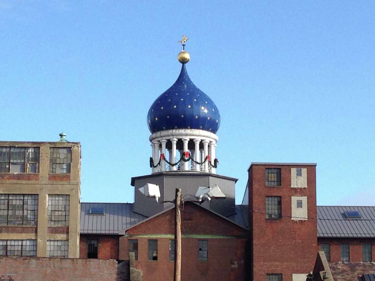 In this Dec. 17, 2014 photo, a blue onion-shaped dome sits atop Samuel Colt's 19th century gun factory in Hartford, Conn., and is perhaps the best known symbol of a bygone era. As the decade-long push to make a national park out of the now-closed gun factory won approval in Washington, elected officials hailed the project as a way to boost one of Hartford's poorest neighborhoods and honor the revolver as a marvel of manufacturing. Notably absent was Colt's Manufacturing Co. _ the company that, somewhat uncomfortably, remains based today in a state still reeling from the Newtown shootings and now sporting some of the nation's strictest gun laws. (AP Photo/Michael Melia)