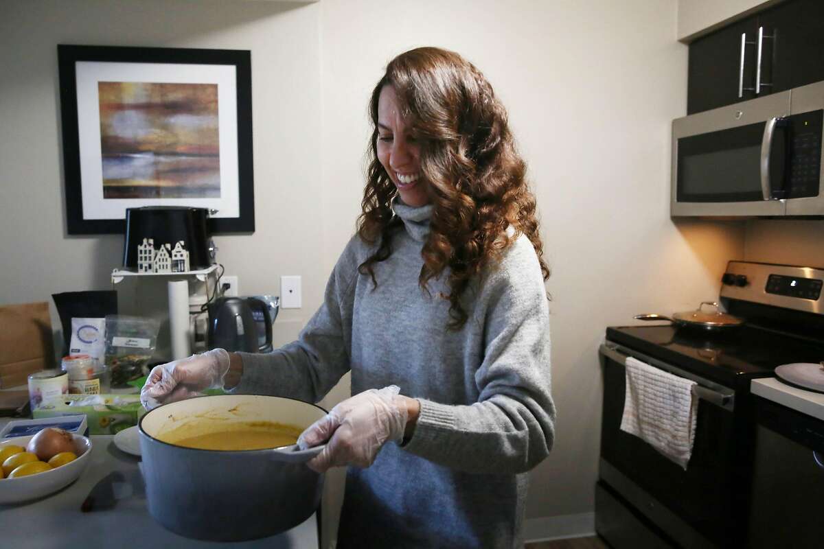 Shereen Hassan-Aly carries a pot full of her Organic Creamy Lentil Soup Shorbat Adas as she works in a space she uses as a test kitchen on Friday, February 12, 2021 in Newark, Calif.