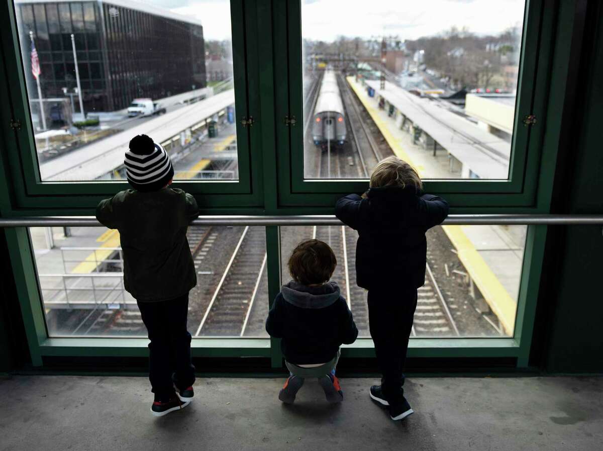 A group of kids excitedly watch as a train passes through the Metro-North station in Greenwich, Conn. on Tuesday, Dec. 1, 2020. New Haven Line ridership is down 80 percent during the COVID crisis.