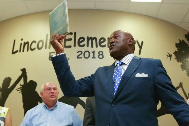 Montgomery City Councilman TJ Wilkerson, who graduated from the original Lincoln High School, holds up his yearbook during the grand opening for Lincoln Elementary School on Tuesday, Aug. 7, 2018, in Montgomery.