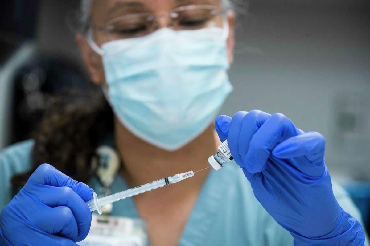 Sochi Evans, pharmacy technician, fills a syringe with Pfizer-BioNTech Covid-19 vaccine at Texas Southern University Feb. 11, 2021 in Houston. Baylor St. Luke's Medical Center is partnering with TSU to begin administering vaccines to some of the most vulnerable populations.